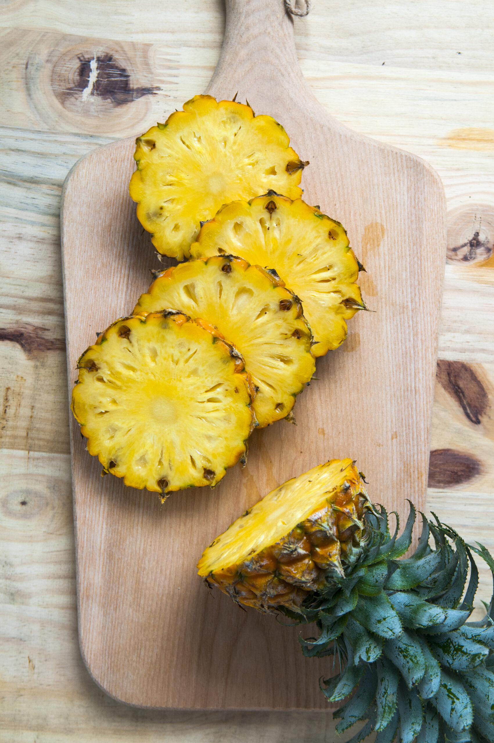 high-angle-view-pineapples-cutting-board-table