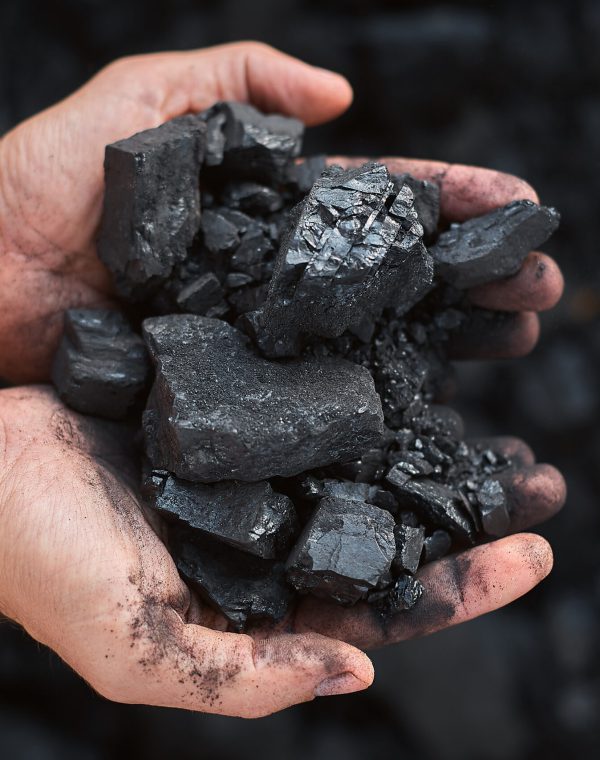 poor middle-aged man holding the hands of stone coal for sale to provide food for his family